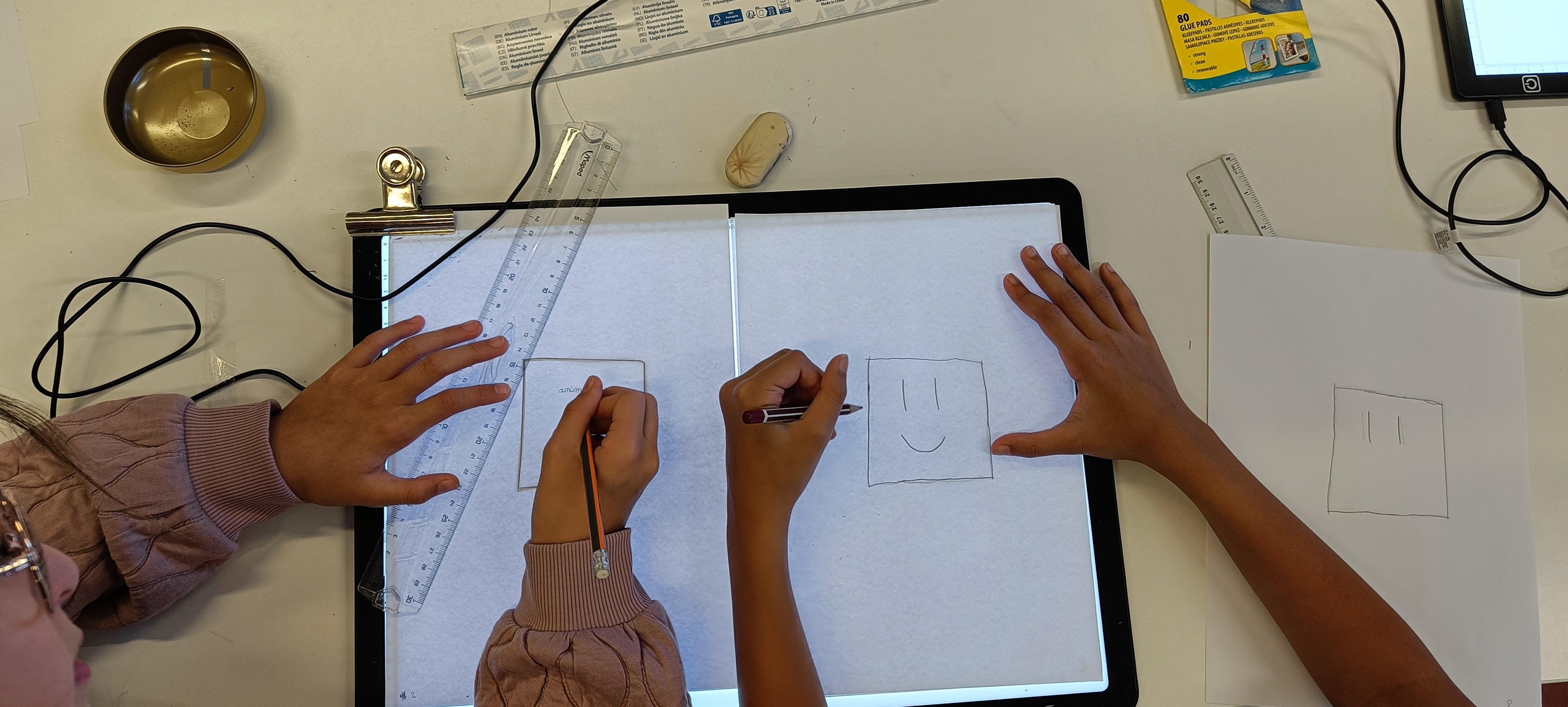 Mains d'enfants qui dessinent sur une tablette numérique