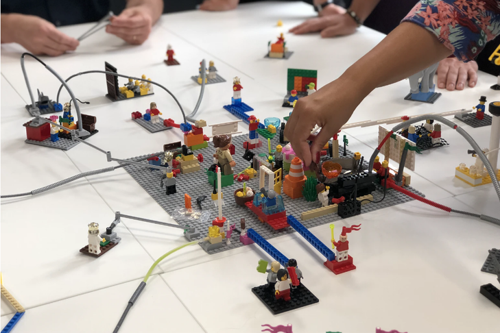 Des mains de personnes jouant aux Legos